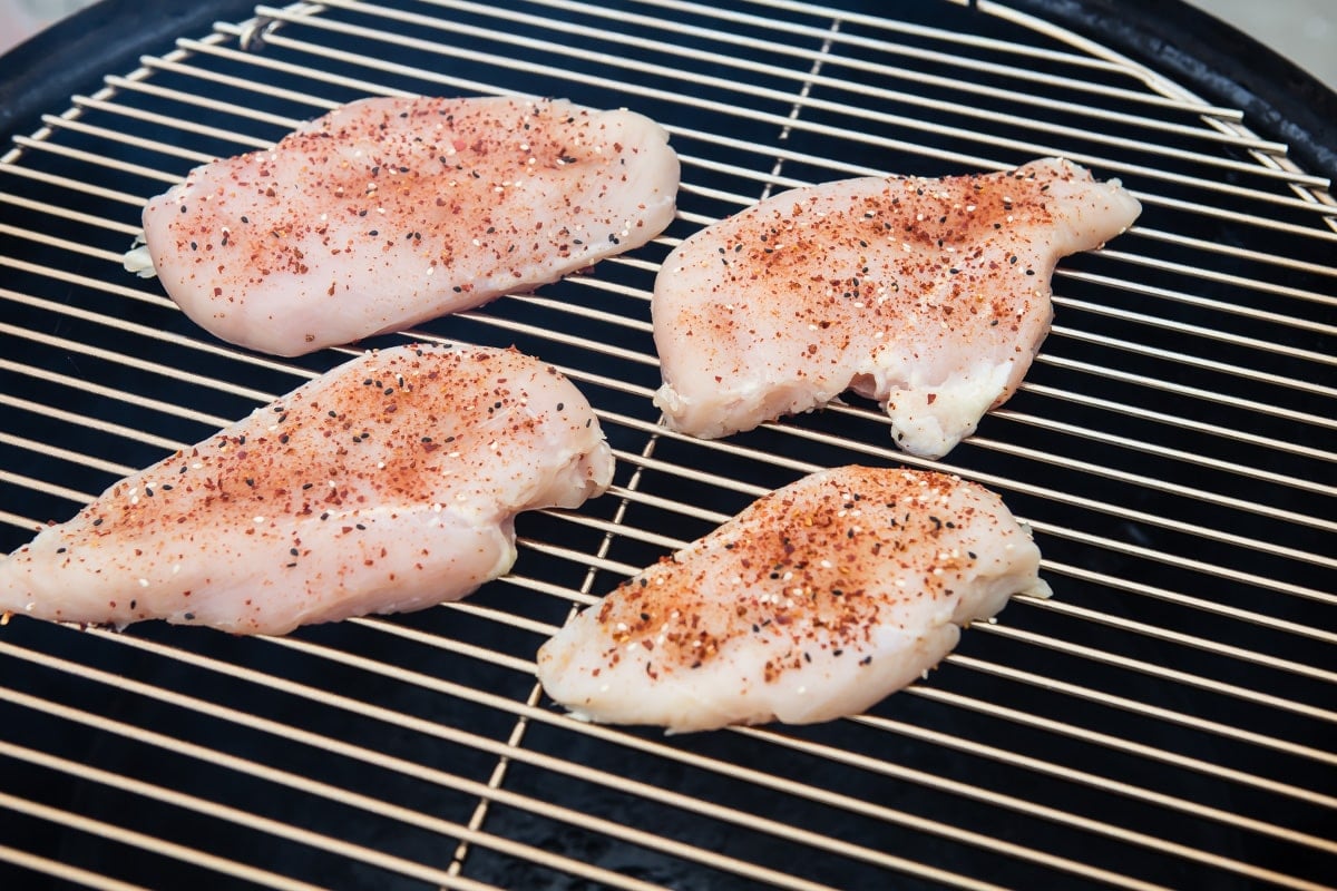 Chicken breasts to be smoked on a charcoal smoker.
