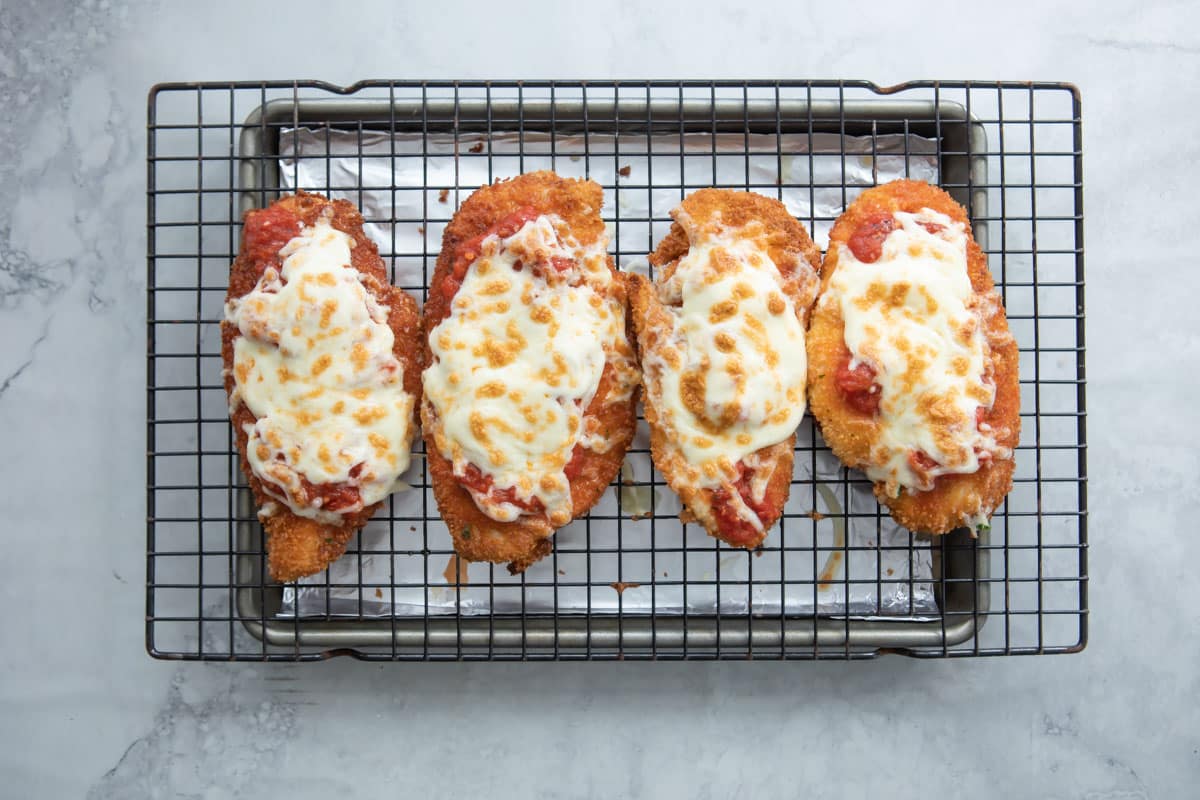 Chicken Parm cutlets with sauce and mozzarella heated on top.