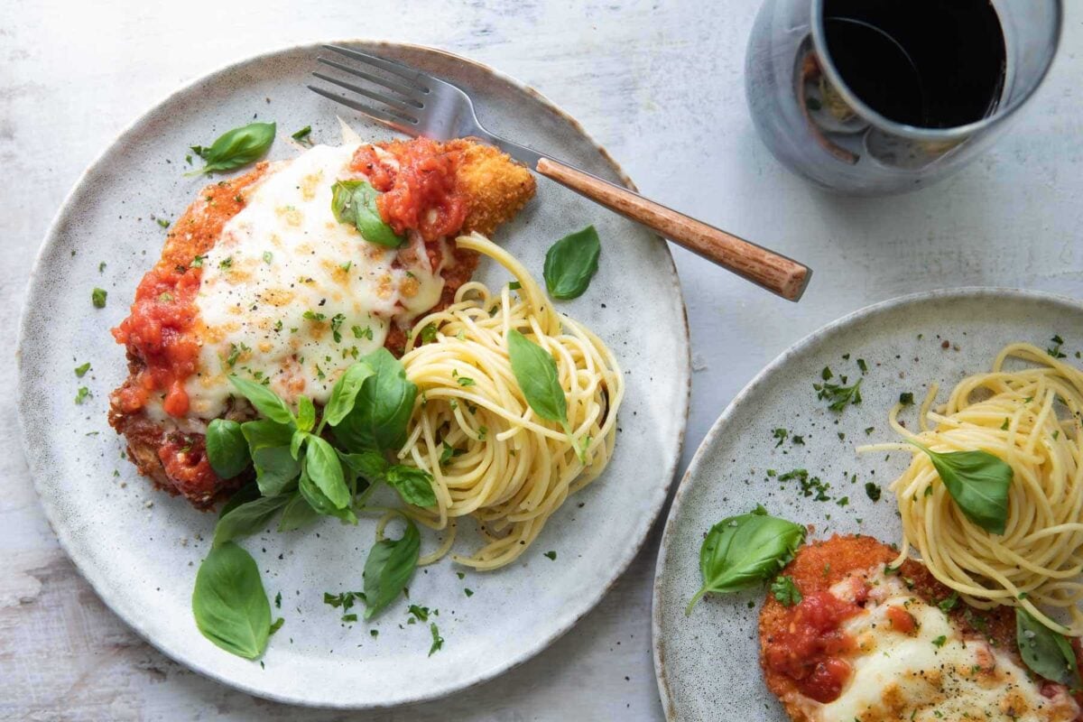 Chicken Parmesan plated with spaghetti.