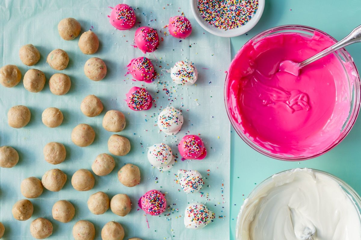 Coating Circus Animal Cookie Truffles in white and pink candy coating.