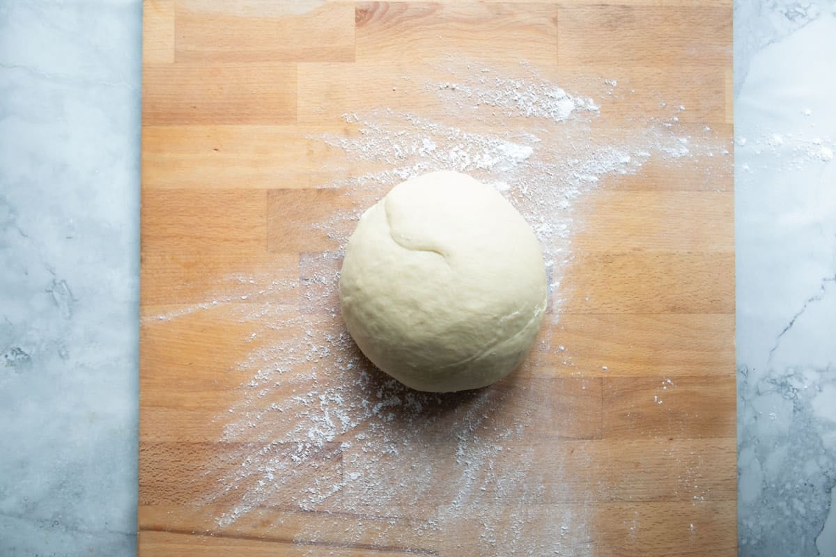 A ball of dough on a cutting board.