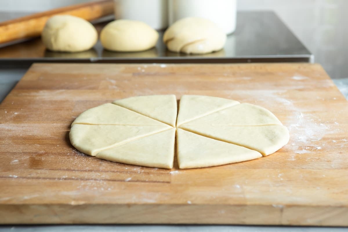 A portion of dough rolled into a circle and cut into 8 pieces.