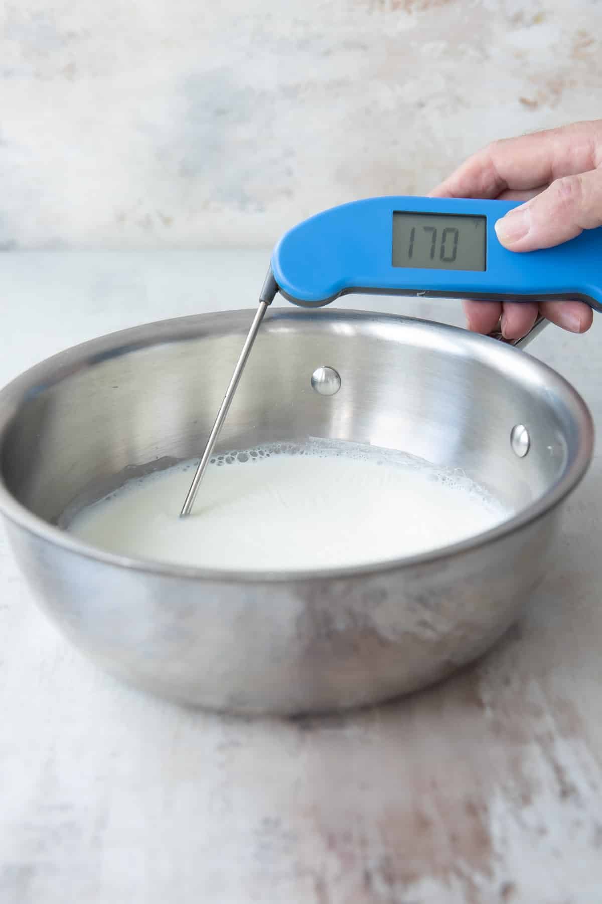 A pot of scalded milk with a thermometer.