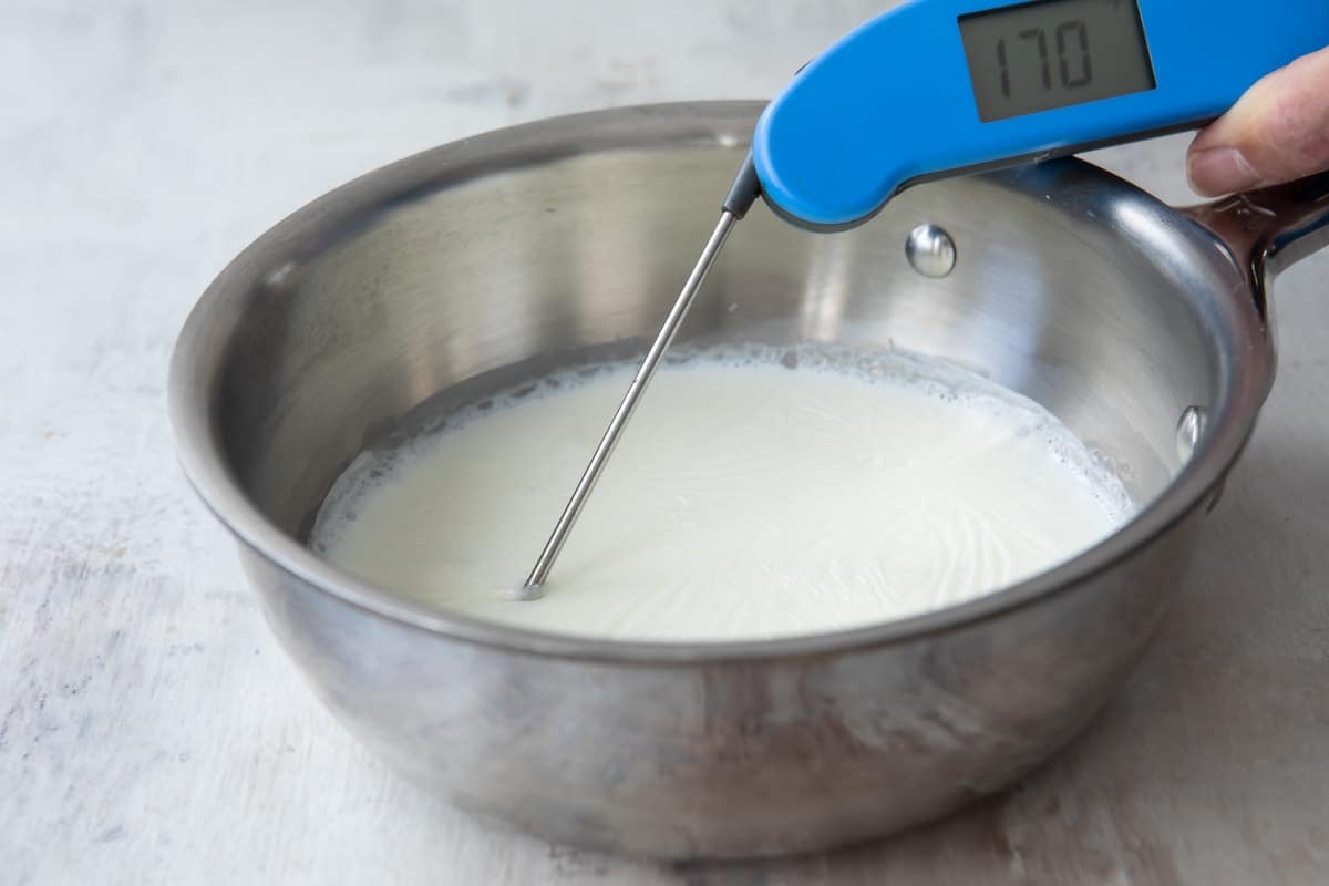 A pot of scalded milk with a thermometer.