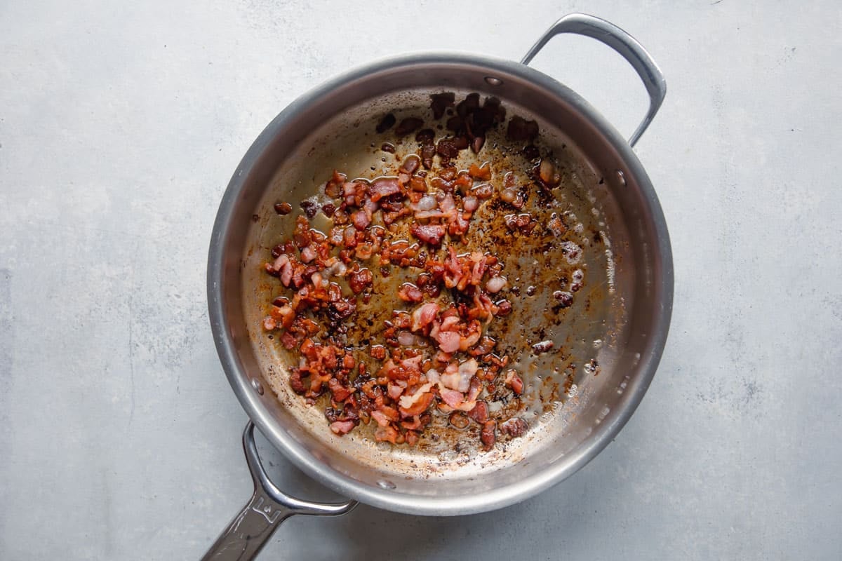 Bacon cooking in a skillet.