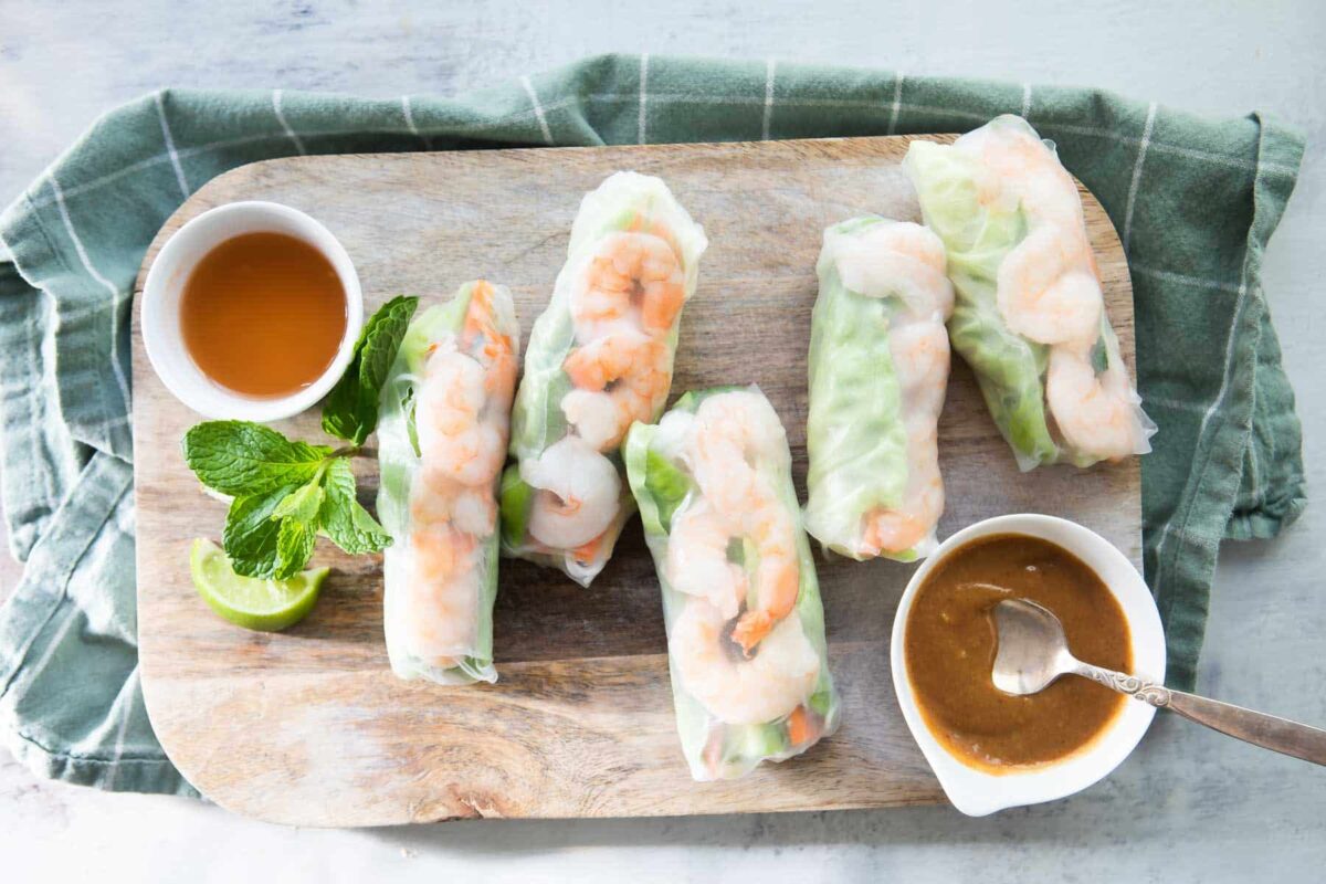 A board of Vietnamese shrimp rolls with dipping sauces.