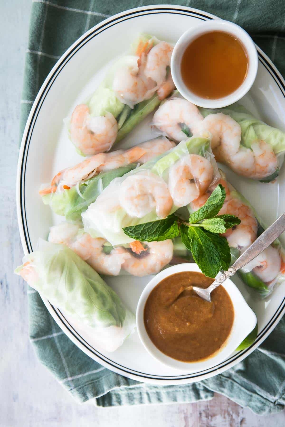 A platter of Vietnamese shrimp rolls with dipping sauces.