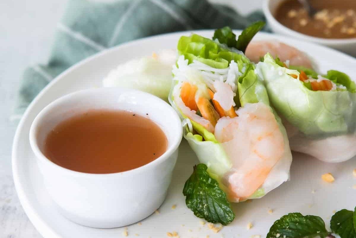 A platter of Vietnamese shrimp rolls with dipping sauces.