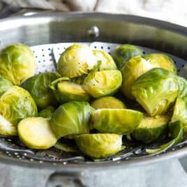 Brussels sprouts in a steamer basket.