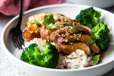 A plate of Teriyaki chicken with rice and steamed broccoli.